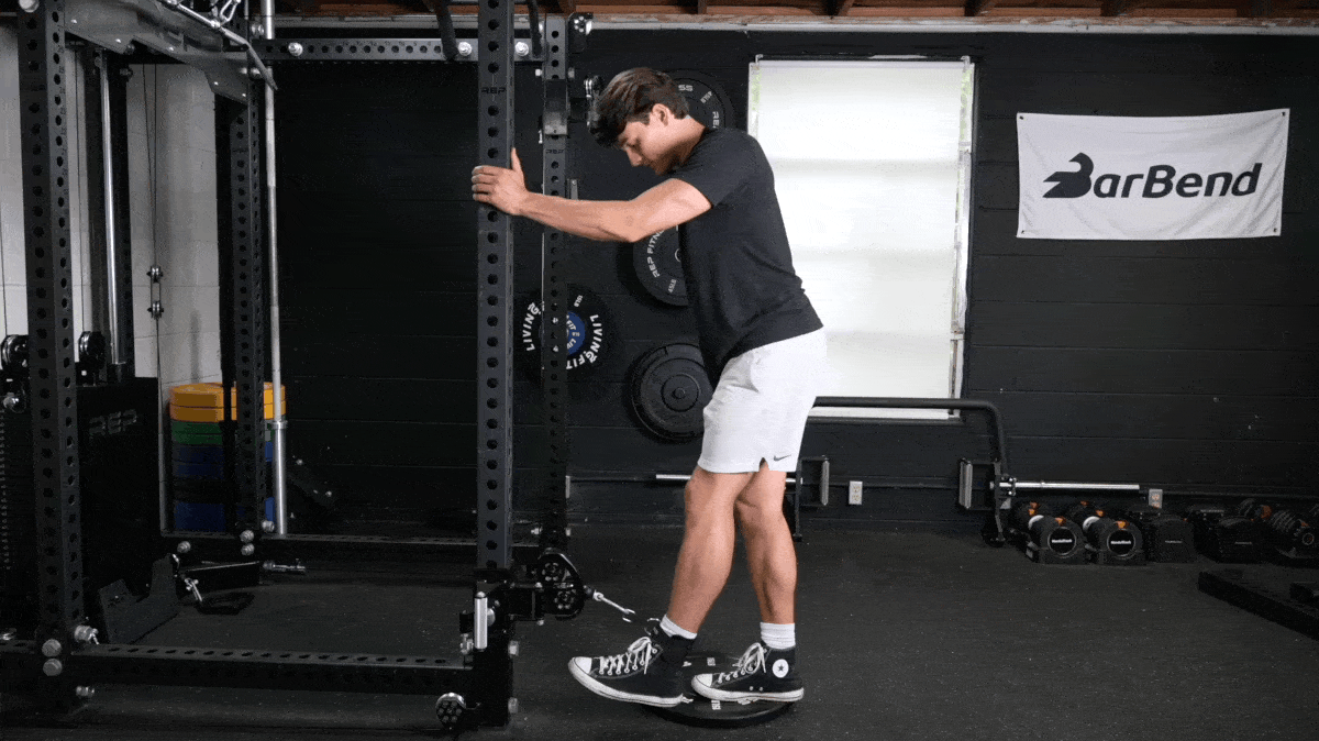 BarBend's Jake Herod performing the cable glute kickback exercise.
