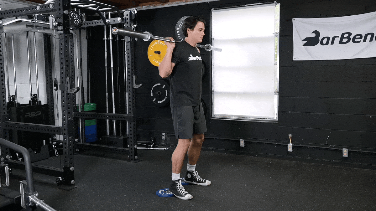 BarBend's Jake Herod performing the heel-elevated back squat exercise.