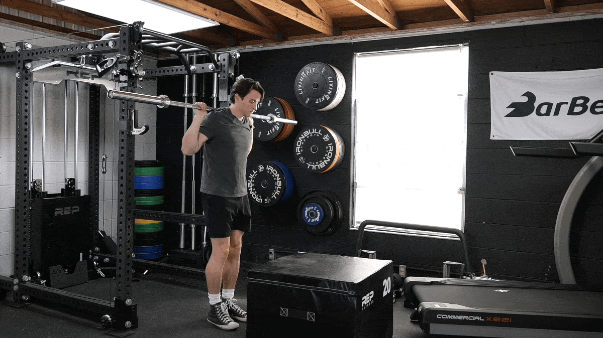 A person doing the barbell step up movement.